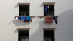Migrant workers look out of windows in a dormitory, amid the coronavirus disease (COVID-19) outbreak in Singapore May 15, 2020. REUTERS/Edgar Su