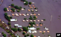 FILE - Only the tops of houses emerge from the water in the city of Santa Fe, Argentina, some 400 kilometers (250 miles) northwest of Buenos Aires, May 1, 2003.