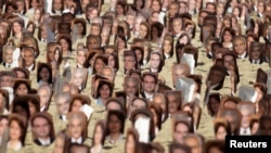 در برزیل، در یک تجمع، عکس هایی از رهبران بهائیان ایران که زندانی بودند، در دست مردم بود. 