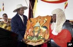 FILE - Uganda's long-time president Yoweri Museveni receives a shield as a symbol of power from the Chief Justice, as his wife Janet Museveni, left, looks on during an inauguration ceremony in the capital Kampala, May 12, 2016.