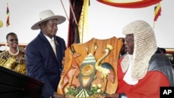 Uganda's long-time president Yoweri Museveni, 71, center left, receives a shield as a symbol of power from Chief Justice Bart Katureebe, right, as his wife Janet Museveni, left, looks on during an inauguration ceremony in the capital Kampala, Thursday, May 12.