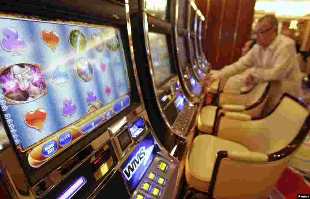 Men play on slot machines during the opening of Solaire Casino-Resort in Pasay city, Metro Manila, Philippines.