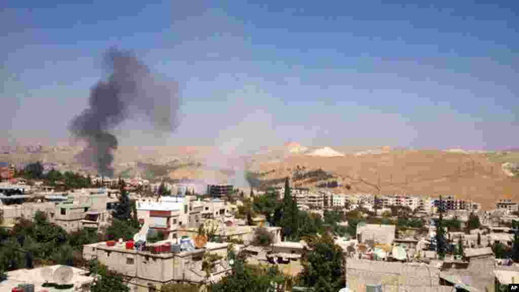 This citizen journalism image provided by the United media office of Arbeen shows black smoke from government forces shelling in Damascus, Sept. 1, 2013.