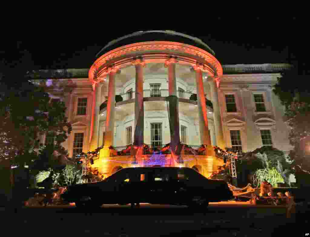 The South Portico of the White House in Washington decorated and lit in orange lights for Halloween, Oct. 30, 2013.