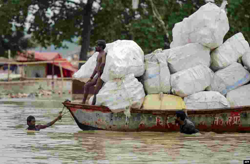 Hindu priests of Sangam move their shelters to drier ground on the banks of the Ganges river, as the water level of the Ganges and Yamuna rivers rises rapidly during monsoon rains in the region, in Allahabad, India.