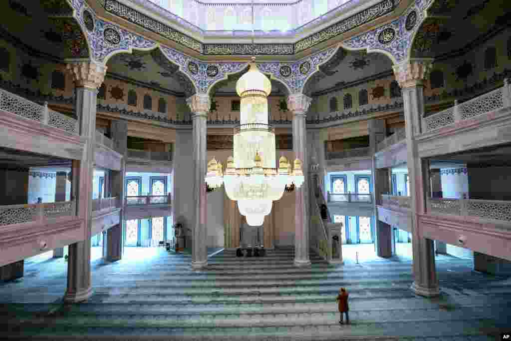 A believer and a group of mullahs attend a Friday prayer in the Moscow Cathedral Mosque in Moscow, Russia.