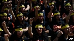 People protesting against human trafficking and slavery raise their fists during a demonstration in Mexico City, Oct. 14, 2017. Dozens of people participated in Mexico City's silent "Walk for Freedom."