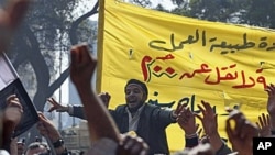 Public transportation workers protest in demand of salary raises in front of the national TV building, right, in Cairo, Egypt, February 14, 2011