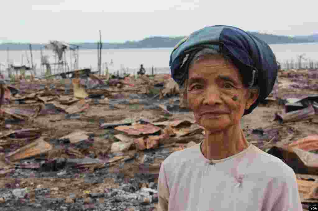 2012年11月，一位妇女站在被焚毁的若开邦穆斯林社区皎漂(Kyauk Phyu)前。 (D. Schearf/VOA)