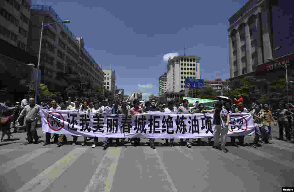 16일 중국 쿤밍에서 정유공장 건설에 반대하는 시위대가 대형 현수막을 행진하고 있다.