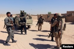 Afghan Special Forces and policemen prepare themselves for battle with the Taliban on the outskirts of Lashkar Gah capital of Helmand, Afghanistan, Oct. 10, 2016.