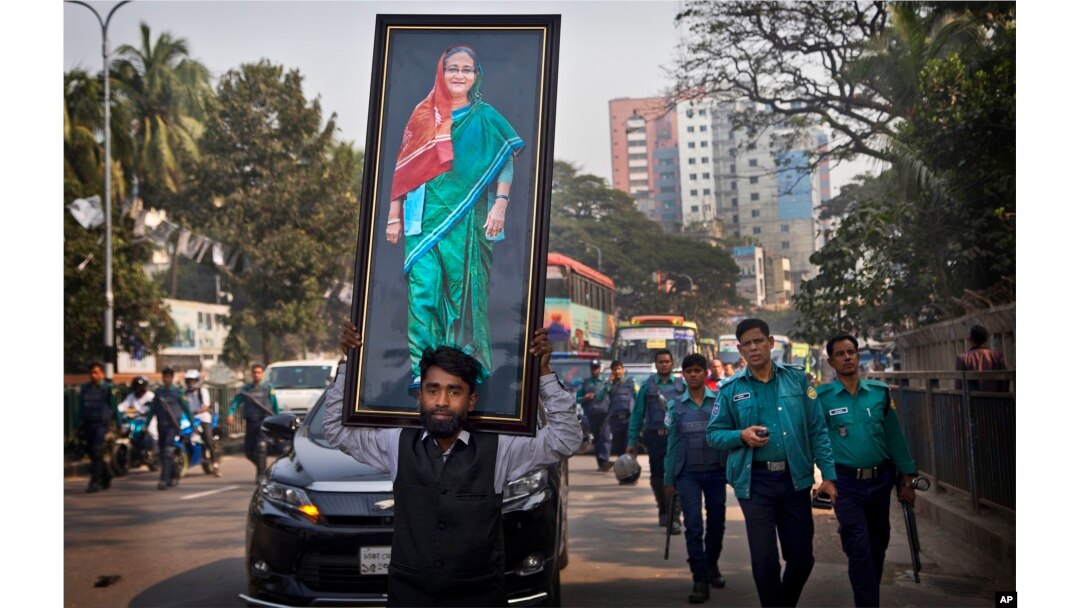 A supporter of Bangladesh Awami League party carries a huge photograph of Bangladesh Prime Minister Sheikh Hasina during an election rally in Dhaka in Bangladesh, Thursday, Dec. 27, 2018.