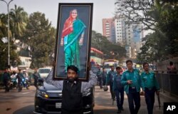A supporter of Bangladesh Awami League party carries a huge photograph of Bangladesh Prime Minister Sheikh Hasina during an election rally in Dhaka in Bangladesh, Thursday, Dec. 27, 2018.