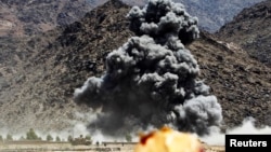 FILE - An explosion is seen after airstrikes during fighting with insurgents in Afghanistan.