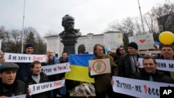 People shout slogans as they stand next to a statue of Ukrainian poet Taras Shevchenko, during a rally against the breakup of the country in Simferopol, Crimea, Ukraine, Sunday, March 9, 2014.