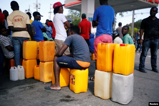 People stand in line waiting to buy fuel, in Port-au-Prince, Haiti, Feb. 13, 2019.