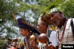 FILE - Indigenous people from various tribes dance as they wait to deliver a letter to Brazil's President-elect Jair Bolsonaro at a transitional government building in Brasilia, Brazil, Dec. 6, 2018.