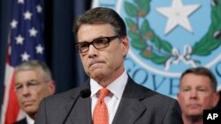Gov. Rick Perry listens to a reporter's question during a news conference in the governor's press room in Austin, Texas, July 21, 2014.