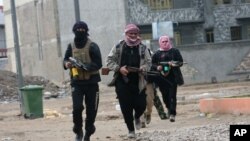 Gunmen patrol during clashes with Iraqi security forces in Fallujah, 40 miles (65 kilometers) west of Baghdad, Iraq, Jan. 5, 2014. 