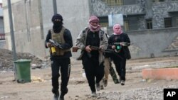 Gunmen patrol during clashes with Iraqi security forces in Fallujah, 40 miles (65 kilometers) west of Baghdad, Iraq, Jan. 5, 2014. 