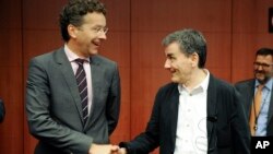 Menteri Keuangan Uni Eropa Jeroen Dijsselbloem (kiri) berjabat tangan dengan Menkeu Yunani, Euclid Tsakalotos dalam pertemuan di Brussels, Belgia (foto: dok).