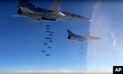FILE - In this photo made from video released from Russian Defense Ministry official website on Friday, Nov. 20, 2015, Russian air force Tu-22M3 bombers drop bombs on a target in Syria.