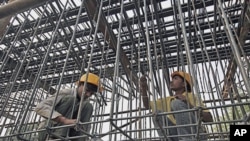 Laborers work at a flyover construction site in Mumbai, 29 Dec 2010