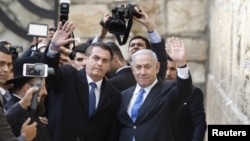 Brazilian President Jair Bolsonaro, accompanied by Israeli Prime Minister Benjamin Netanyahu, pose for a photo as they visit the Western Wall in Jerusalem's Old City, April 1, 2019.