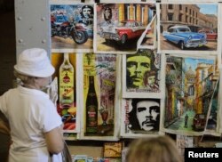 گردشگران آثار هنری براساس تصاویر چه گوارا، از رهبران انقلاب کوبا، را در نمایشگاه صنعتگران در هاوانا (پايتخت)، از نظر می‌گذرانند