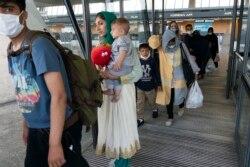Keluarga Afghanistan yang berhasil dievakuasi dari Kabul, saat tiba di bandara internasional Washington Dulles, di luar Washington DC (23/8).