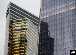 FILE - Goldman Sachs world headquarters, left, neighbors One World Trade Center, in New York, Oct. 28, 2015.