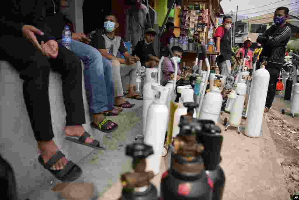 People queue to refill their oxygen tanks at a filling station in Jakarta, Indonesia.