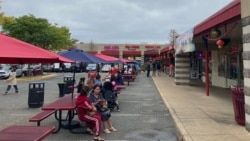 Visitors eat and talk outside Eden Center shops. (Dan Novak)