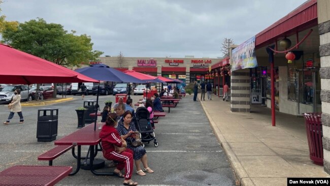 Visitors eat and talk outside Eden Center shops. (Dan Novak)