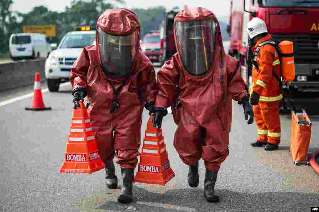 Members of a Malaysian hazardous disaster emergency response team wearing protective suits take part in a trasportation emergency response drill 'Ex-Eagle' on a highway near Bentong, outside Kuala Lumpur.