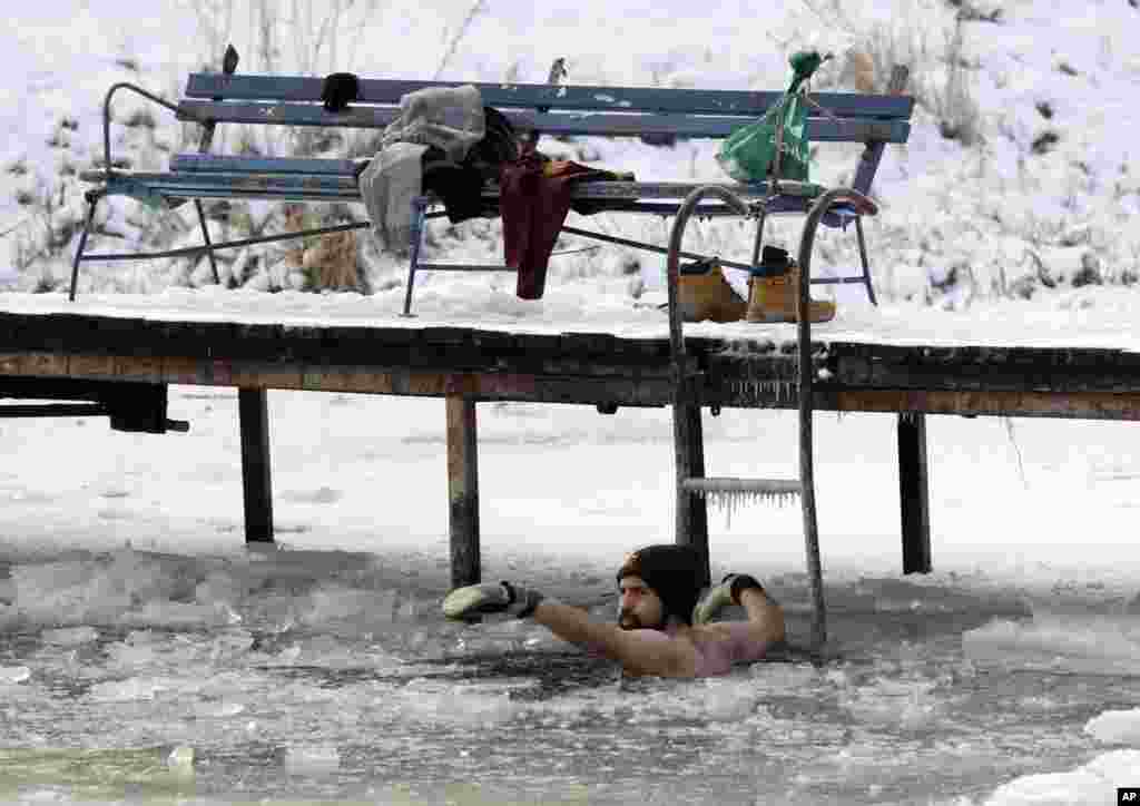 A man bathes in the icy waters of the Dziekanowskie Lake near Lomianki, Poland, in temperatures as low as -12° C (10° F).