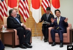 U.S. Secretary of State Mike Pompeo, left, and Japanese Prime Minister Shinzo Abe speak during a meeting at Abe's office in Tokyo, Oct. 6, 2018. Pompeo was in Tokyo for talks with Japanese officials ahead of his trip to North Korea.