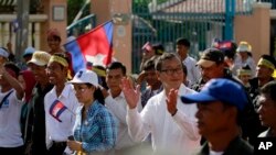 ကမ္ဘောဒီးယားအတိုက်အခံခေါင်းဆောင် Sam Rainsy (လယ်) နှင့် သူ့အားထောက်ခံသူများ မြို့တော် ဖနွမ်းပင်မှာ ဆန္ဒပြနေစဉ်။ (စက်တင်ဘာ ၁၅၊ ၂၀၁၃)