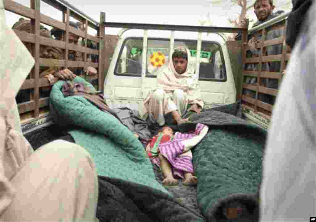 EDS NOTE GRAPHIC CONTENT - A man sits in the back of a truck with the bodies of several men and a child allegedly killed by a U.S. service member in Panjwai, Kandahar province south of Kabul, Afghanistan, Sunday, March 11, 2012. A U.S. service member wal