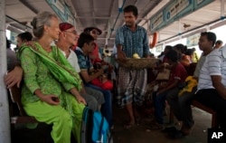 FILE - In this April 13, 2017 photo, Elizabeth Brenner, 62, in green dress, sits on a crowded steamer boat along with her partner Barry Knight near Gangasagar, West Bengal, India. Brenner's son died during a study abroad trip to the mountains of India more than five years ago.
