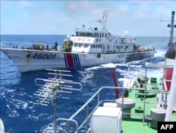FILE - Screen grab shows the Chinese Coast Guard ship 46001 (L) chasing a Vietnamese vessel near to the site of the Chinese oil rig in the disputed waters in the South China Sea, off Vietnam's central coast.