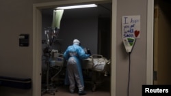 Para pekerja medis memeriksa pasien Covid-19 yang baru diterbangkan dari El Paso untuk dirawat di United Memorial Medical Center di Houston, Texas, Kamis, 12 November 2020. (Foto: Reuters)