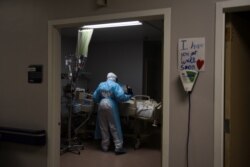 Seorang pekerja medis memeriksa pasien Covid-19 yang baru diterbangkan dari El Paso untuk dirawat di United Memorial Medical Center di Houston, Texas, Kamis, 12 November 2020. (Foto: Reuters)