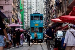 Sebuah trem melewati pasar jalanan di distrik North Point Hong Kong pada 5 November 2021. (Foto: AFP)