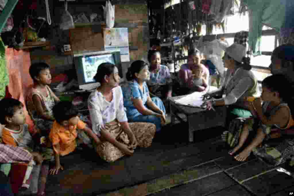 A Myanmar census enumerator asks questions to a family member while collecting information in Dala township Sunday, March 30, 2014, in Yangon, Myanmar. Enumerators fanned out across Myanmar on Sunday for a census that has been widely criticized for stoki
