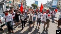 Demonstrators march with placards calling for the release of detained Myanmar State Counselor Aung San Suu Kyi in Yangon, Myanmar Tuesday, Feb. 9, 2021. Protesters continued to gather Tuesday morning in Yangon. (AP Photo)