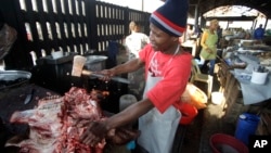 In this file photo, a butcher cuts a cows head at the early morning market, Thursday, June 24, 2010, in Durban, South Africa. (AP Photo/Rick Bowmer)