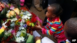 An unidentified young girl lays flowers outside the Mediclinic Heart Hospital where former South African President Nelson Mandela is being treated in Pretoria, June 27, 2013. 
