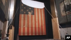 In this Nov. 20, 1998 file photo, workers at the Smithsonian's National Museum of American History cover the flag that inspired "The Star Spangled Banner," prior to the flag's restoration.