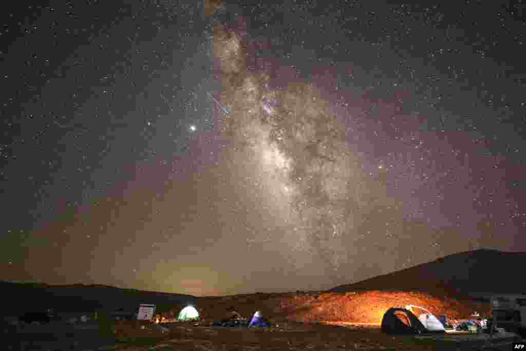A Perseid meteor streaks across the sky above a camping site at the Negev desert near the city of Mitzpe Ramon, Israel, Aug. 11, 2020, during the Perseids meteor shower.